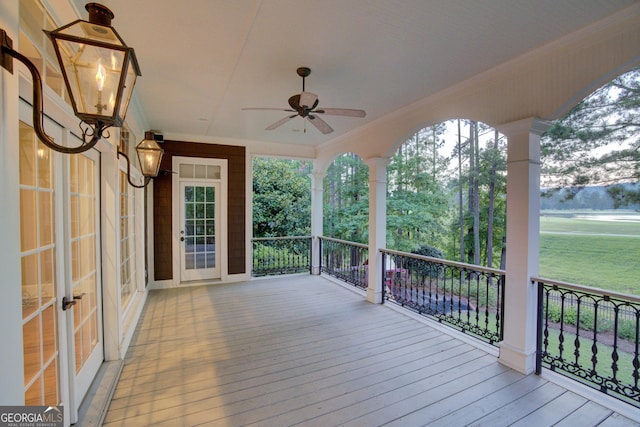 wooden deck with ceiling fan and french doors