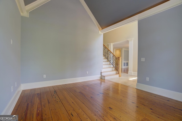 spare room featuring ornamental molding, light hardwood / wood-style floors, and decorative columns