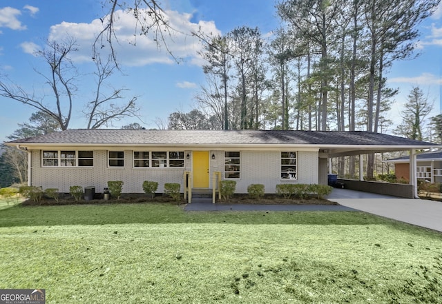 single story home with an attached carport, concrete driveway, brick siding, and a front lawn