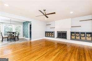 unfurnished living room featuring hardwood / wood-style floors and ceiling fan