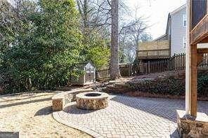 view of patio / terrace featuring a storage shed and a fire pit