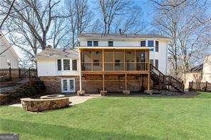 rear view of house featuring a sunroom, a yard, a patio area, and french doors