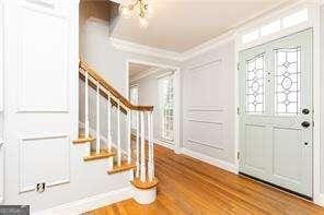 foyer featuring wood-type flooring and ornamental molding