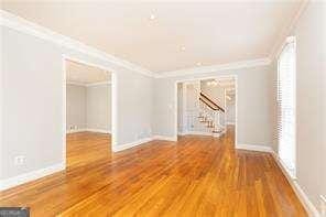 unfurnished room featuring hardwood / wood-style floors and ornamental molding