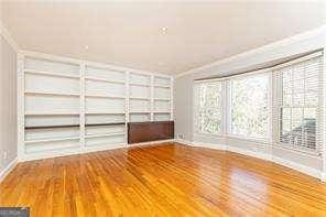 unfurnished living room featuring ornamental molding and hardwood / wood-style floors