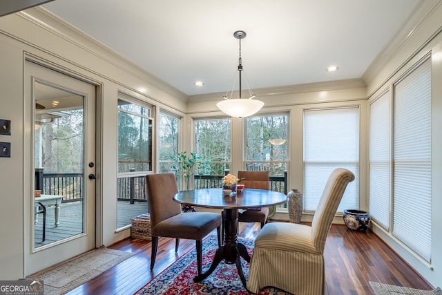 dining space featuring ornamental molding and dark hardwood / wood-style flooring