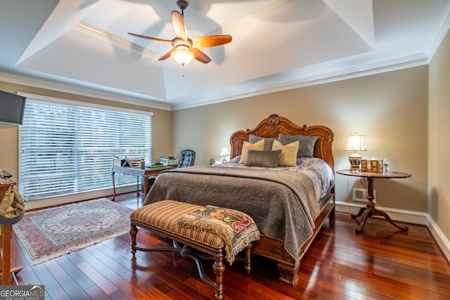 bedroom with crown molding, dark hardwood / wood-style floors, a raised ceiling, and ceiling fan