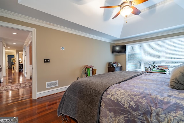 bedroom featuring a raised ceiling, ornamental molding, dark hardwood / wood-style floors, and ceiling fan