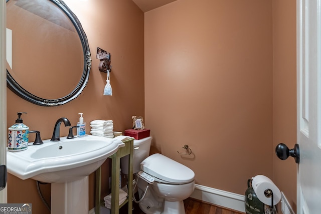 bathroom with wood-type flooring and toilet