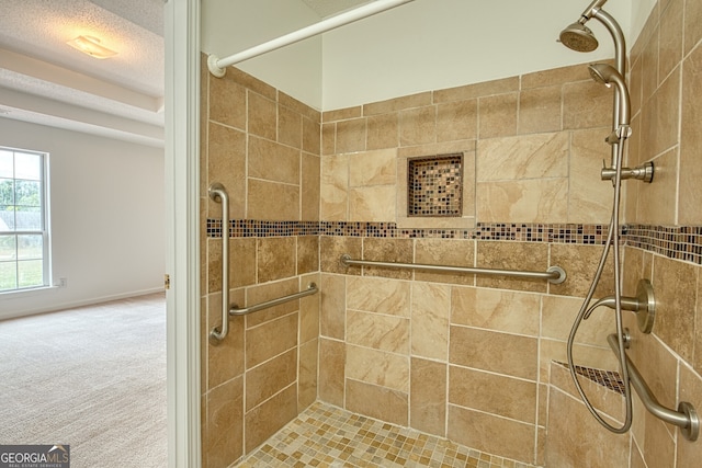 bathroom with a textured ceiling and a stall shower