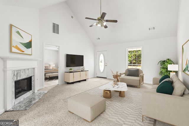 carpeted living room featuring high vaulted ceiling, a fireplace, visible vents, and a ceiling fan