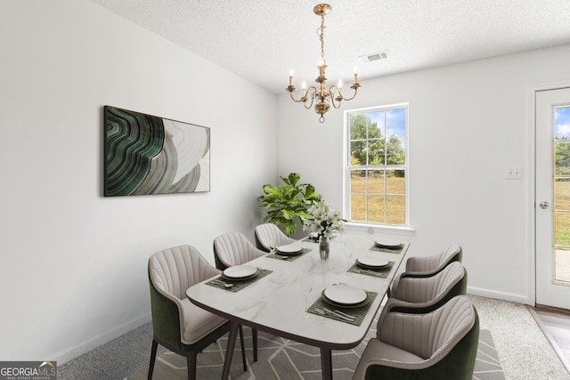 dining space with baseboards, visible vents, a chandelier, and a textured ceiling