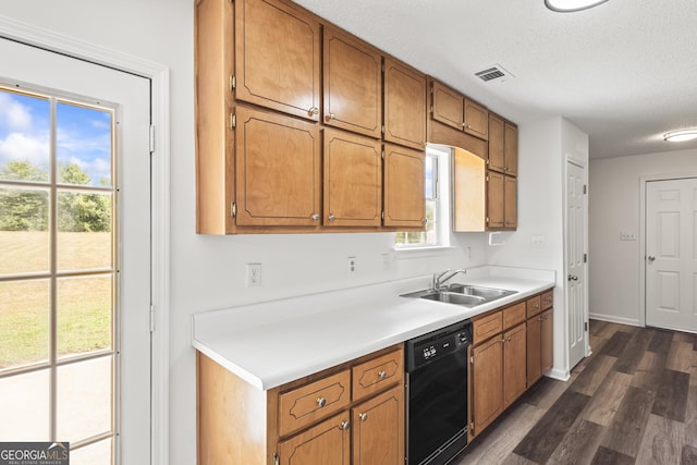 kitchen featuring dark wood-style flooring, light countertops, brown cabinetry, a sink, and dishwasher