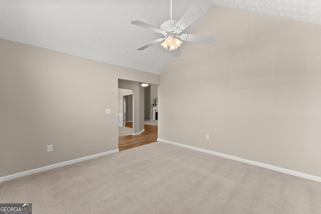 carpeted spare room with ceiling fan, high vaulted ceiling, and a textured ceiling