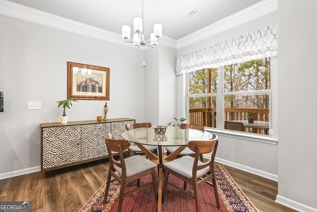 dining room with visible vents, baseboards, wood finished floors, and crown molding