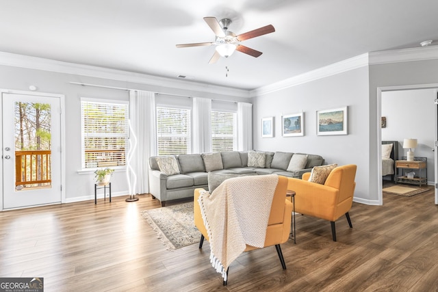 living area featuring baseboards, wood finished floors, and crown molding