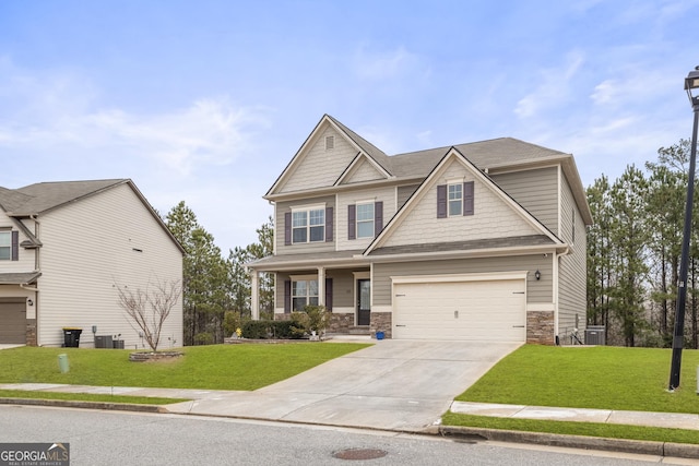 craftsman house with stone siding, an attached garage, concrete driveway, and a front lawn