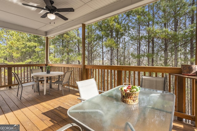 wooden deck featuring outdoor dining space and a ceiling fan