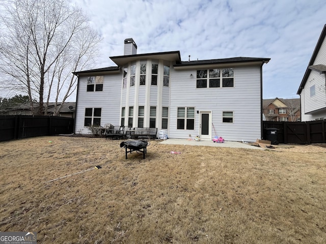 rear view of house with a patio area, a lawn, and an outdoor fire pit