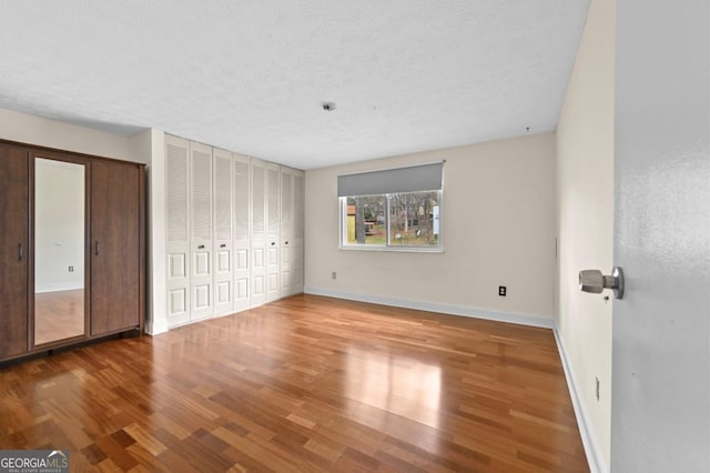 unfurnished bedroom featuring wood-type flooring and a textured ceiling