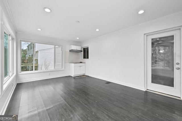 unfurnished living room featuring dark wood-type flooring and ornamental molding