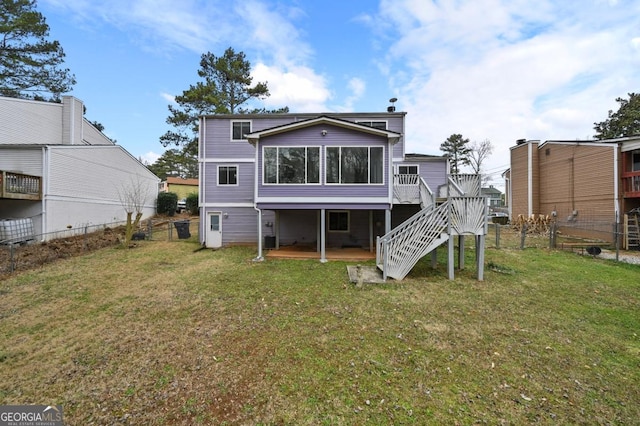 back of house featuring a wooden deck and a yard