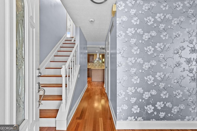 stairs featuring hardwood / wood-style flooring and a textured ceiling