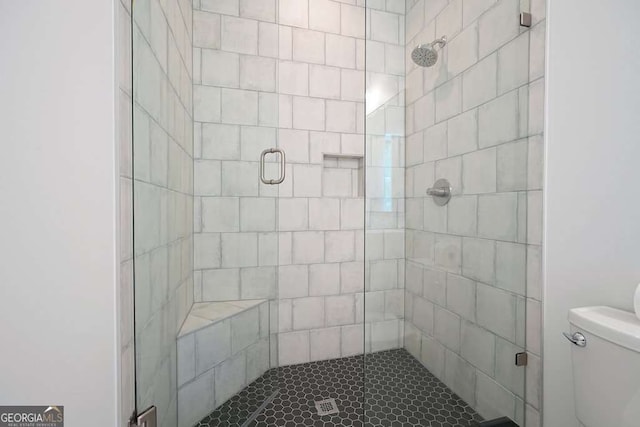 bathroom featuring a shower stall and toilet