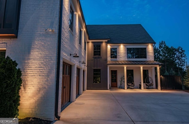 view of front facade featuring metal roof, brick siding, and a standing seam roof