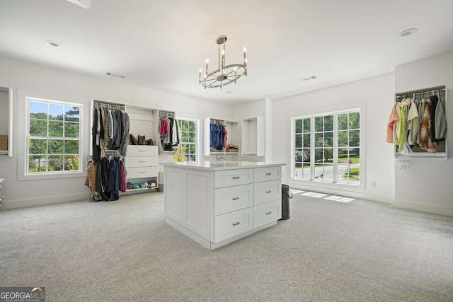 walk in closet featuring a chandelier, light colored carpet, and visible vents