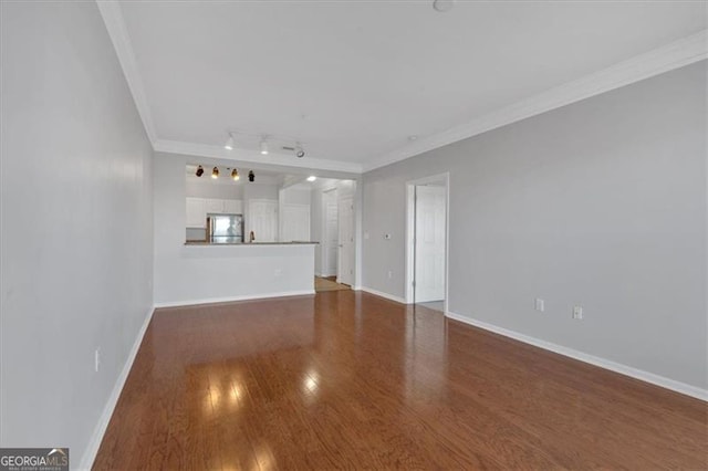 unfurnished living room with ornamental molding, dark hardwood / wood-style floors, and track lighting