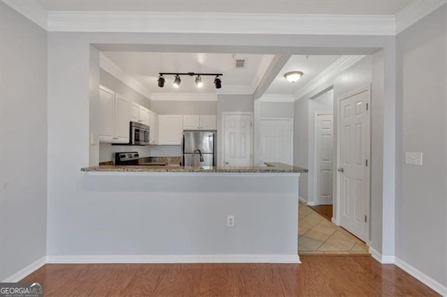 kitchen featuring appliances with stainless steel finishes, white cabinetry, light hardwood / wood-style floors, kitchen peninsula, and light stone countertops