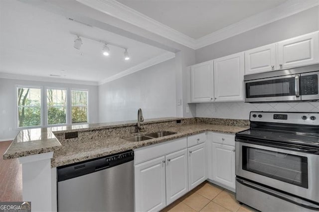 kitchen featuring appliances with stainless steel finishes, kitchen peninsula, sink, and white cabinets