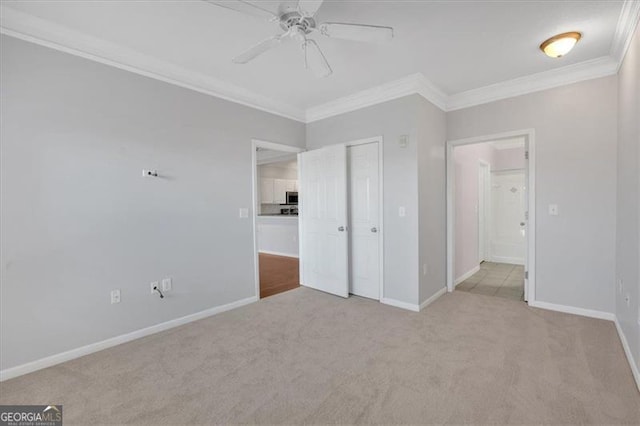 unfurnished bedroom with crown molding, a closet, ceiling fan, and light carpet