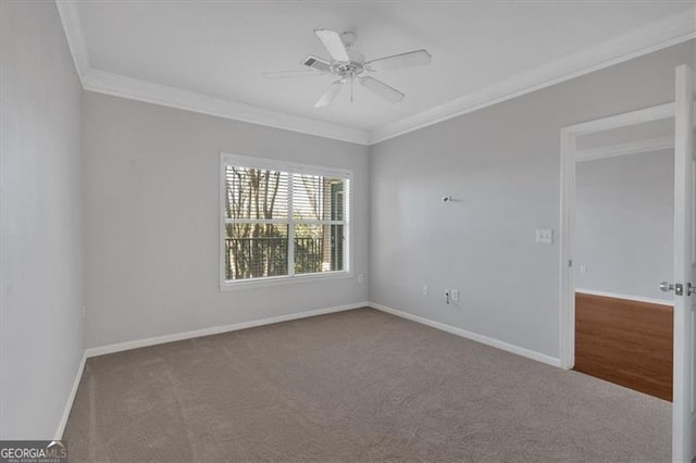 empty room with crown molding, ceiling fan, and carpet flooring