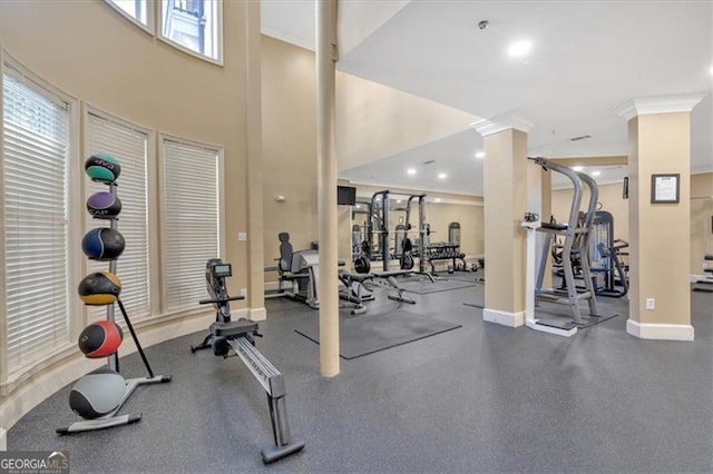 gym featuring ornate columns and ornamental molding