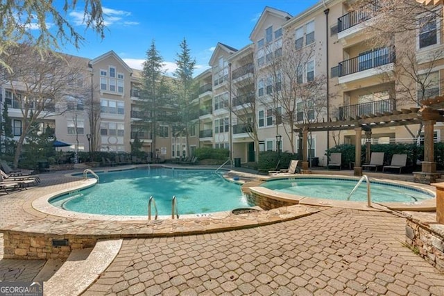 view of swimming pool featuring a pergola and a community hot tub