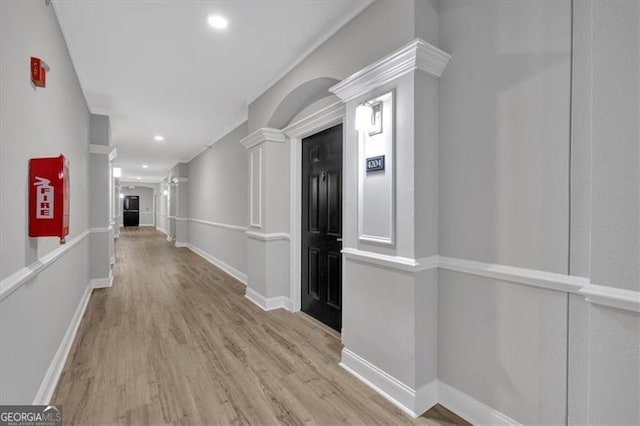 hallway featuring light hardwood / wood-style flooring and decorative columns