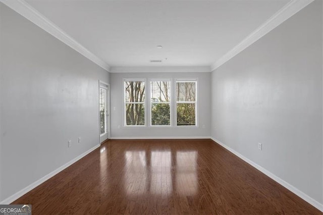 empty room with crown molding and dark wood-type flooring