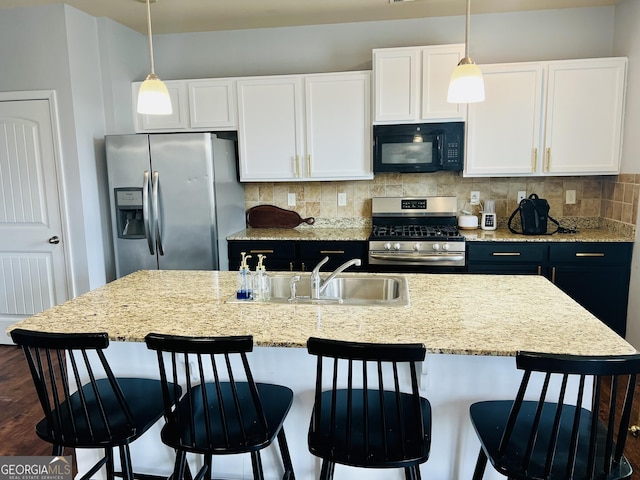 kitchen featuring white cabinetry, decorative backsplash, stainless steel appliances, and hanging light fixtures