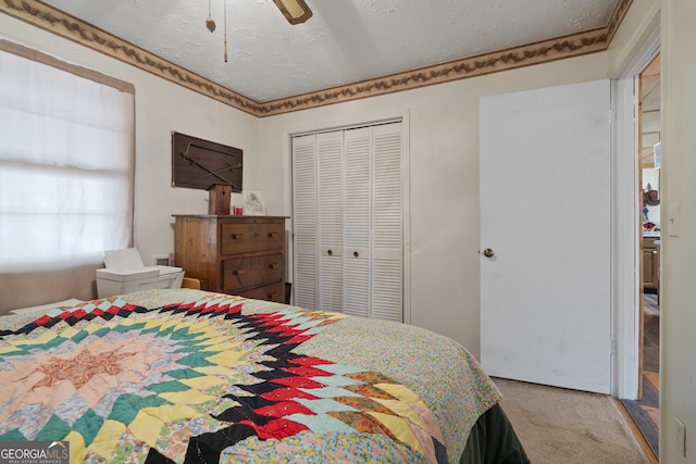 bedroom featuring ceiling fan, carpet floors, a textured ceiling, and a closet