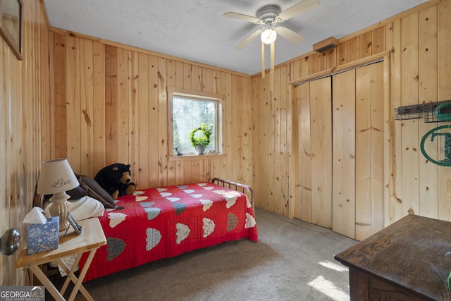 carpeted bedroom with a textured ceiling and wood walls