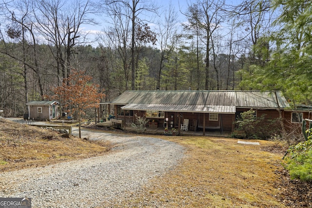 ranch-style house with a porch and a storage shed