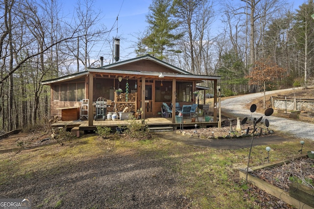 back of house with a wooden deck and a sunroom