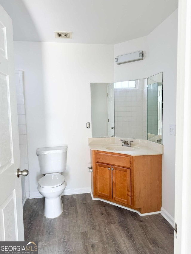 bathroom featuring vanity, toilet, and hardwood / wood-style floors