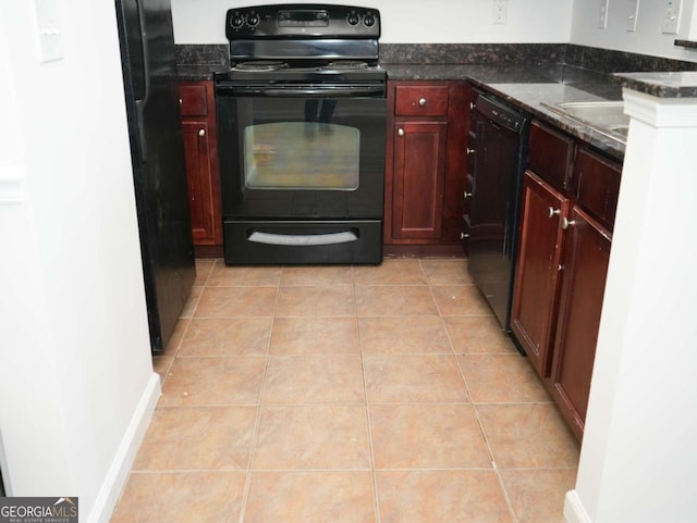 kitchen featuring dark stone countertops, light tile patterned floors, and black appliances