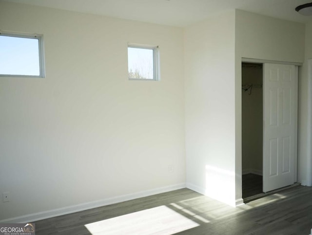 unfurnished bedroom featuring dark hardwood / wood-style flooring and a closet