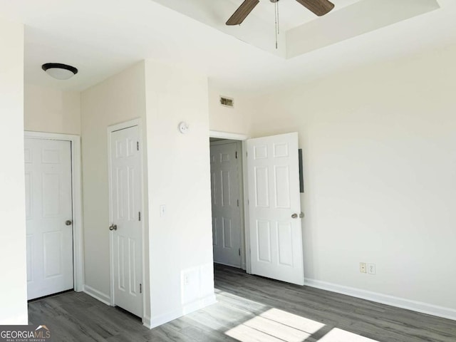 unfurnished bedroom featuring dark wood-type flooring and ceiling fan