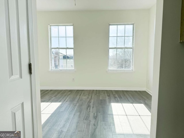 empty room with a healthy amount of sunlight and light hardwood / wood-style floors