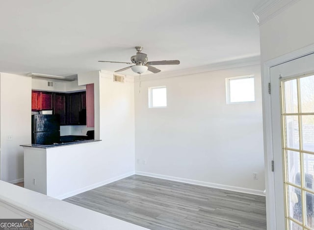 kitchen with black refrigerator, ceiling fan, light hardwood / wood-style flooring, and a wealth of natural light